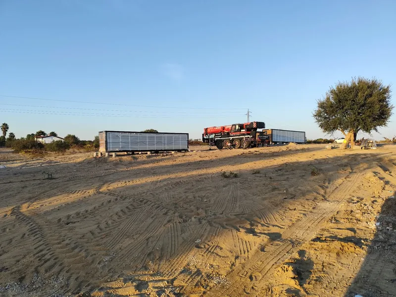 Duas casas modulares no local durante os trabalhos de instalação