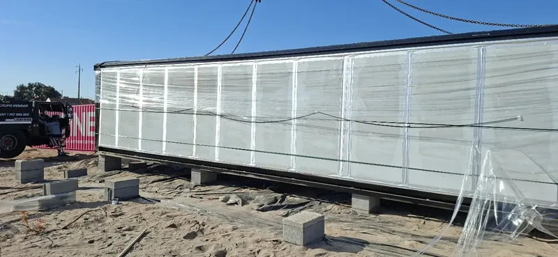 Módulo de casa modular no terreno, com uma grua ao lado